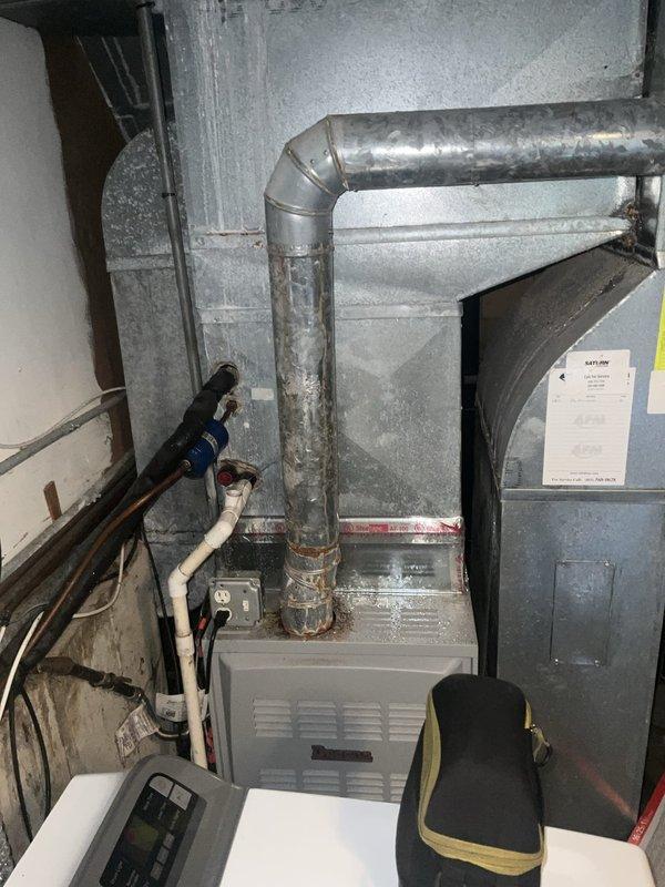 Responded to no cooling call at residential property. Upon arrival, inspected outdoor condensing unit and found condensate safety switch tripped due to blocked drain line. Cleared obstruction from condensate drain system, verified proper drainage flow, and tested float switch operation. Proceeded to indoor air handler in basement and inspected furnace/evaporator coil assembly and associated condensate piping. Confirmed all PVC drain lines were flowing freely and verified proper pitch on horizontal drain runs. Reset safety switch, restored power to system, and verified compressor startup. System tested successfully with proper cooling operation restored. Documented equipment condition with photos showing outdoor unit top panel and indoor mechanical room configuration.