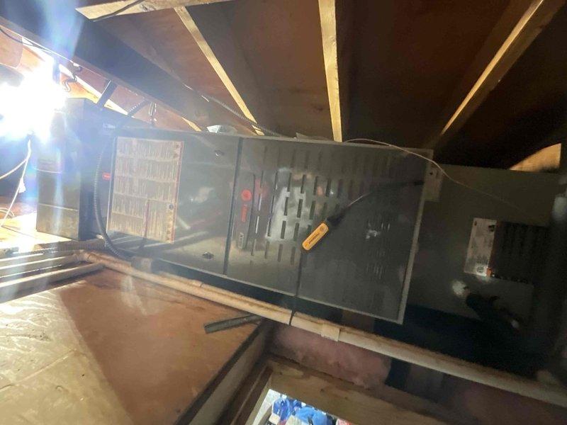 Completed comprehensive air conditioning tune-up on 8+ year old system during afternoon service window. Upon inspection, found evaporator coil heavily clogged with dust, dirt, and debris accumulation, significantly restricting airflow and reducing system efficiency. Thoroughly cleaned coil fins to restore proper heat transfer capability. Inspected attic-mounted air handler unit, verified proper operation, and checked all accessible components including refrigerant lines and drainage system. Documented pre-service conditions showing substantial contamination on outdoor condenser coil with thick buildup obscuring metal fin structure. Performed standard maintenance protocol including filter inspection, electrical connection verification, and operational testing to ensure system running at optimal performance levels.