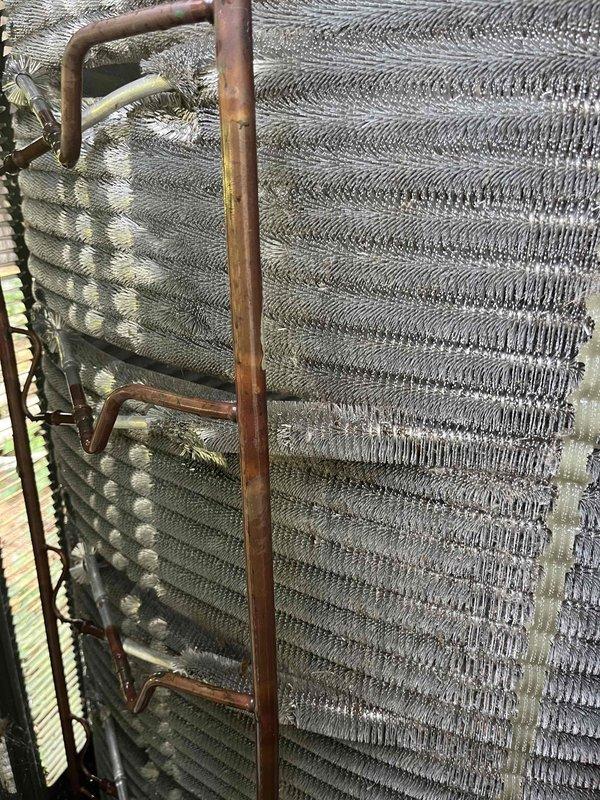 Completed comprehensive BFMA tune-up on residential HVAC system including air conditioning unit and furnace. Performed thorough inspection of outdoor condenser coil assembly and refrigerant lines, noting copper tubing showing normal age-related patina with no active leaks detected. Inspected evaporator coil fins for proper airflow and debris accumulation. Replaced air filter with clean unit, removing filter showing dust accumulation from normal operation. Verified all mechanical components operating within manufacturer specifications. Additionally inspected recently installed water heater and confirmed proper installation and operation with no issues identified. All systems tested and left in proper working order.