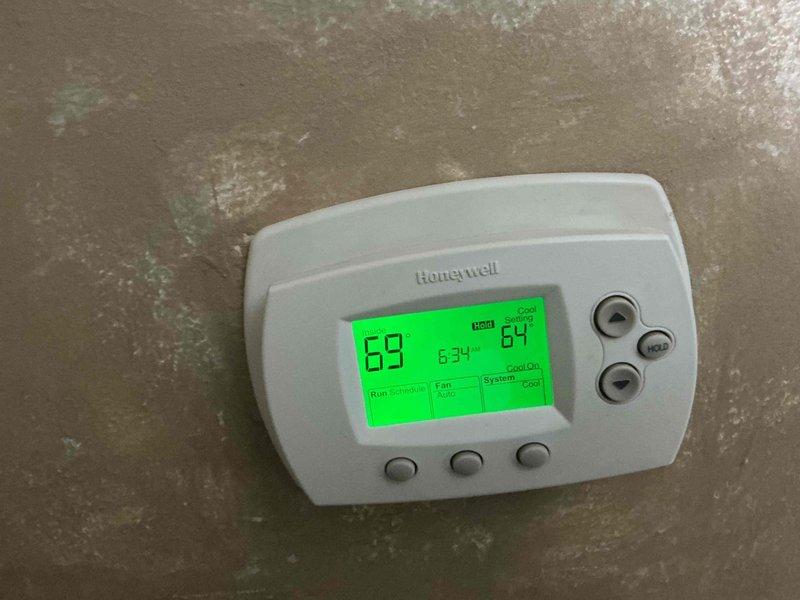 Completed comprehensive BFMA air conditioning tune-up on 2-year-old residential cooling system. Performed full preventive maintenance inspection including thermostat operation verification, outdoor condenser unit examination, and system performance assessment. Unit operating properly with thermostat displaying 89°F current temperature and 87°F setpoint in cooling mode, confirming proper system functionality and customer comfort.