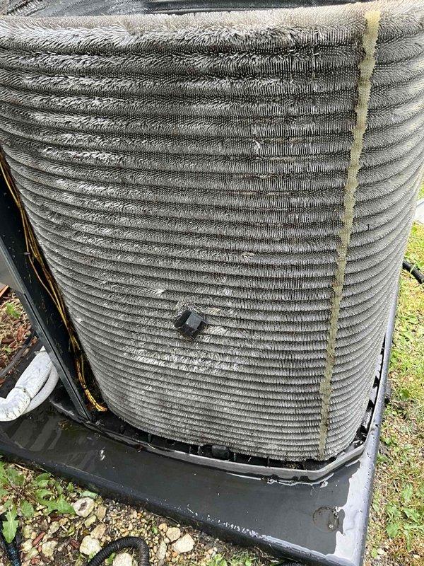 Completed comprehensive BFMA tune-up service on outdoor condensing unit with 5+ years of operation. Performed standard maintenance protocol including system inspection, coil assessment, and operational testing. Unit exhibited significant fin damage with bent and crushed sections on condenser coil, along with accumulated dirt, debris, and environmental contamination between fins. Noted deteriorated foam insulation material present on exterior coil surfaces and visible discoloration indicating age-related wear. Documented equipment condition with photographic evidence showing compromised coil integrity that may impact heat transfer efficiency and overall system performance. Recommended monitoring system performance and considering coil straightening or replacement to restore optimal airflow and cooling capacity.