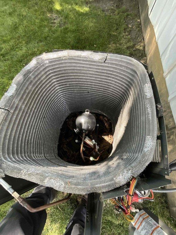 Completed comprehensive BFMA tune-up on 11-month-old residential air conditioning system. Performed standard preventive maintenance protocol including inspection of condenser unit, compressor, and refrigerant lines. Removed top grille to access and inspect cylindrical heat exchanger coil, noting light dust accumulation on concentric fins typical for equipment age. Verified proper operation of compressor unit, checked copper refrigerant line connections and insulation integrity, and inspected electrical connections for security. All components found operating within normal parameters with no deficiencies requiring immediate attention. Unit returned to service in optimal condition.