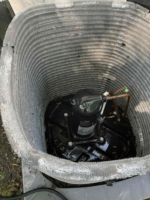 Completed comprehensive BFMA tune-up on 11-month-old residential air conditioning system. Performed standard preventive maintenance protocol including inspection of condenser unit, compressor, and refrigerant lines. Removed top grille to access and inspect cylindrical heat exchanger coil, noting light dust accumulation on concentric fins typical for equipment age. Verified proper operation of compressor unit, checked copper refrigerant line connections and insulation integrity, and inspected electrical connections for security. All components found operating within normal parameters with no deficiencies requiring immediate attention. Unit returned to service in optimal condition.