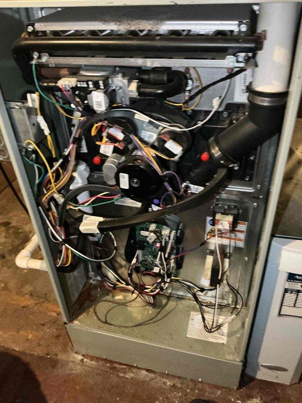 Responded to after hours emergency call for non-operational air conditioning system. Upon arrival, performed diagnostic inspection of HVAC system including furnace and outdoor condensing unit. Removed access panels to examine internal components, wiring connections, and electrical systems. Inspected capacitor, contactors, relays, and associated wiring harnesses for proper function and connections. Evaluated heat exchanger assembly, pressure switches, control boards, and condensate drain lines. Documented system condition with photographs showing all major components and wiring configurations for service records.