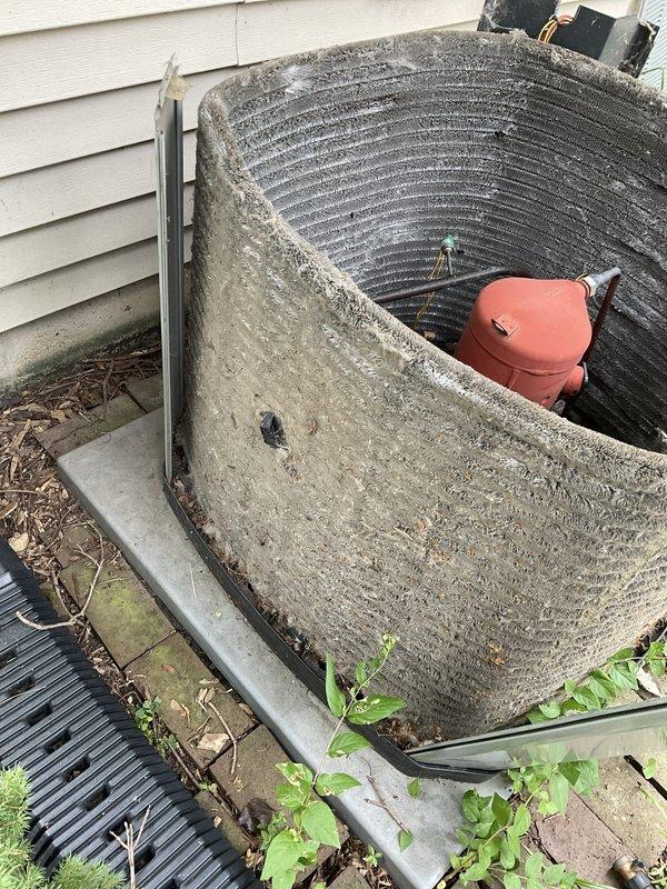 Completed comprehensive BFMA tune-up service on 14+ year old outdoor air conditioning condenser unit. Upon arrival, unit exhibited extensive dirt accumulation, algae growth, and debris buildup on exterior casing and coil fins, with heavy mineral deposits and frost formation affecting heat transfer efficiency. Performed thorough coil cleaning to remove organic matter and encrusted buildup from fin surfaces, cleared vegetation and leaf litter from base and perimeter area, inspected refrigerant lines and electrical connections for proper operation, and verified compressor assembly function. Unit restored to optimal operating condition with improved airflow and heat exchange capacity.