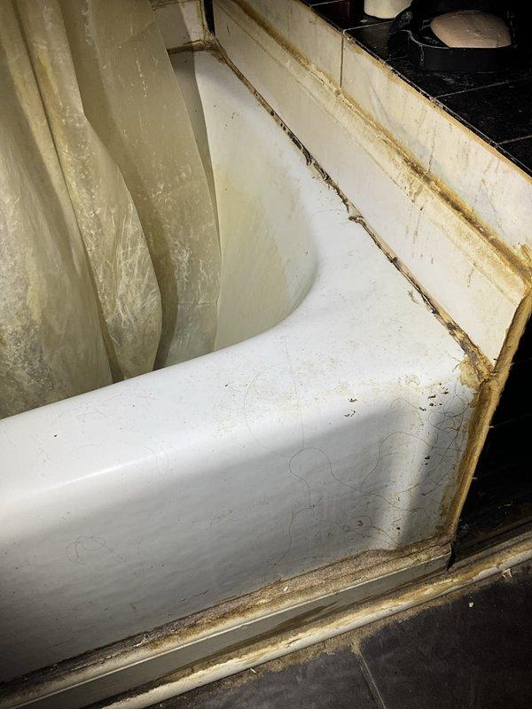 Responded to water leak complaint affecting rec room ceiling with source reported from upstairs bathroom. Upon arrival, conducted thorough inspection of HVAC air handler unit and upstairs bathroom plumbing fixtures. Inspection of air handler revealed significant dust and dirt accumulation throughout interior housing, with brownish discoloration along seams and edges indicating extended operation without maintenance. Examined bathroom facilities and identified potential leak source at toilet base connection. Floor tiles surrounding toilet fixture showed evidence of water damage, including dark staining, discoloration, and moisture accumulation beneath plumbing connections. Documented conditions with photographic evidence for service records. Advised property owner of findings and recommended follow-up maintenance to address HVAC unit cleanliness and toilet seal integrity to prevent further water intrusion.