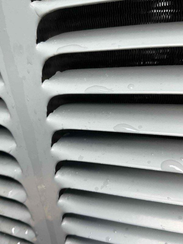 Completed comprehensive BFMA tune-up service on residential air conditioning system aged 4+ years. Performed thorough inspection of outdoor condenser unit, including examination of cabinet condition, fan assembly, and protective grille components. Verified proper installation on concrete pad and assessed surrounding clearances. Inspected evaporator coil assembly, noting moisture present on fins indicating normal operation. Cleaned and evaluated heat exchanger surfaces, checking for debris accumulation and verifying adequate airflow through finned components. Examined refrigerant line insulation and electrical conduit routing along exterior wall. Confirmed all mechanical components operating within specifications. Maintained communication with customer via phone throughout service visit as requested, providing updates on system condition and maintenance activities performed.