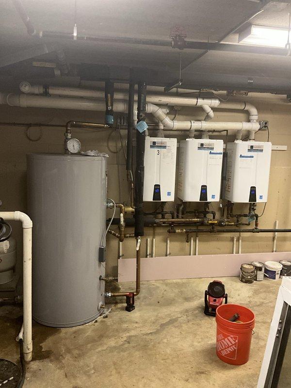 Responded to service call for lukewarm water complaints in multi-unit residential building. Upon inspection, found hybrid water heating system consisting of one tanked water heater and three wall-mounted tankless units. Tested all equipment and verified proper operation of pressure relief valves, thermostats, and heating elements on tanked unit. Checked temperature settings and functionality of all three tankless water heaters, confirmed proper ignition sequences and burner operation. Inspected all copper piping connections, pressure gauges, and isolation valves throughout the system for leaks or restrictions. Verified adequate gas supply and proper venting for tankless units. Documented existing equipment configuration and operational status with photographs for service records.