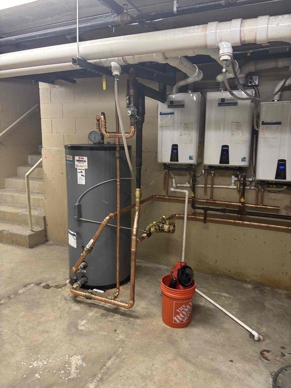 Responded to service call for lukewarm water complaint affecting multiple units. Upon inspection, found hybrid system with one tanked water heater and three wall-mounted tankless units working in tandem. Tested water temperature output from all units, inspected copper supply lines, verified gas supply and electrical connections, and checked all isolation valves and brass fittings for proper operation. Confirmed system configuration and identified potential capacity or sequencing issues with the multi-unit setup requiring further evaluation to restore adequate hot water delivery throughout the building.