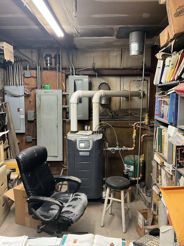 Conducted sales estimate for commercial water filtration system installation in basement mechanical room. Assessed existing plumbing infrastructure including boiler connections, PVC distribution piping with brass fittings, and multiple vertical supply lines with red-handled ball valves for future filtration system integration.