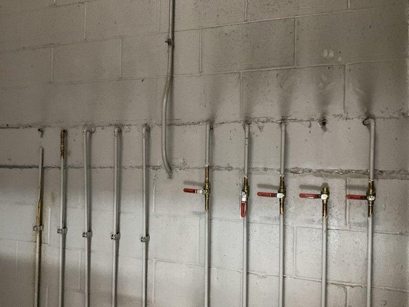 Conducted sales estimate for commercial water filtration system installation in basement mechanical room. Assessed existing plumbing infrastructure including boiler connections, PVC distribution piping with brass fittings, and multiple vertical supply lines with red-handled ball valves for future filtration system integration.