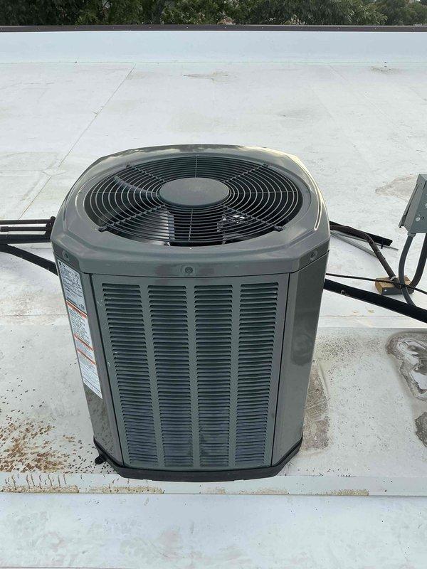 Successfully completed installation of a 2-ton Trane air conditioning system on a commercial rooftop. The condenser unit was manually lifted and positioned through the building's roof hatch access with a three-person crew, eliminating the need for crane equipment. All refrigerant lines, electrical connections, and control wiring were installed per manufacturer specifications, with the system tested and verified operational upon completion.
