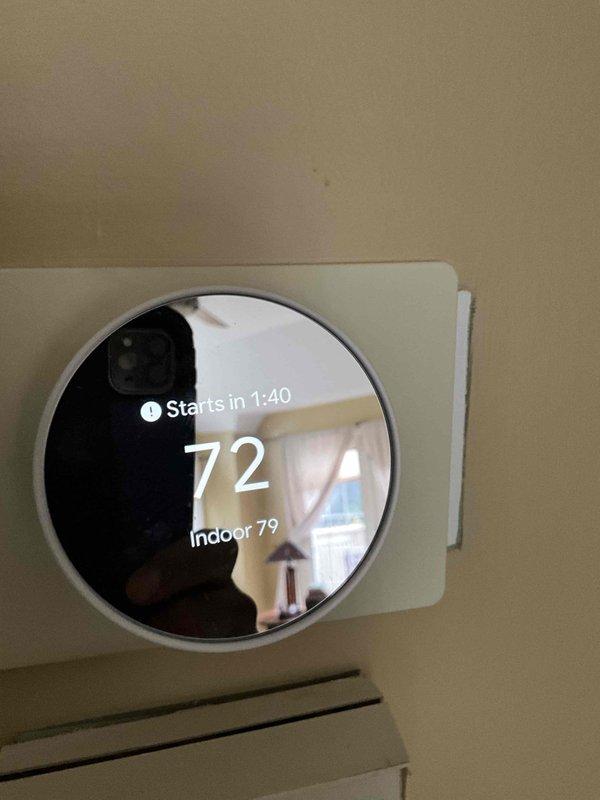 Responded to after hours service call for HVAC system not cooling properly. Upon arrival, found thermostat displaying indoor temperature of 79°F with setpoint at 72°F, indicating system was running but not achieving desired temperature. Inspected mechanical room and discovered furnace unit with significant ceiling damage above equipment, exposing interior structure with compromised drywall and visible backing material. Assessed white PVC vent piping connections running through damaged ceiling area to ensure proper exhaust ventilation remained intact. Verified all HVAC components, including furnace unit and adjacent water heater, were functioning safely despite structural damage to surrounding area. Advised that ceiling damage requires immediate attention to prevent further deterioration and potential impact on system ventilation, though HVAC equipment remains operational at this time.