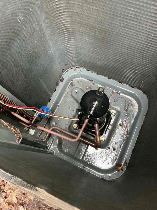 Completed comprehensive BFMA tune-up service on 11-year-old HVAC system during morning appointment window. Performed full AC system inspection and maintenance, including evaluation of compressor unit, refrigerant lines, evaporator coil assembly, and condensate drainage system. Noted rust staining and corrosion present on base pan with moisture accumulation, indicating normal condensate collection activity. Inspected air handler cabinet interior, assessed electrical connections and wiring integrity, and evaluated overall system operation. Replaced 20x25x5 air filter as part of semi-annual filter change service. Documented equipment condition through photographic records showing interior components including compressor assembly, copper refrigerant tubing, evaporator coil, drain pan, and air handler cabinet. System operational upon completion of tune-up procedures.