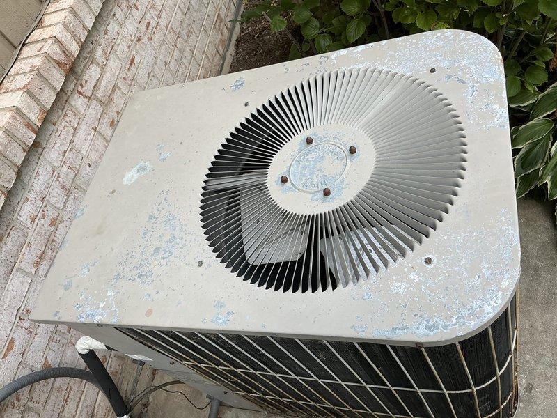 Evaluated existing HVAC system in in-law suite consisting of a 1991 outdoor condensing unit and similarly-aged air handler for full system replacement estimate. The air conditioning unit is struggling to maintain adequate cooling capacity, with visible deterioration including paint flaking and weathering on the outdoor unit housing. Both the condensing unit and furnace are at end of service life and recommended for simultaneous replacement due to age and condition to ensure system compatibility and efficiency.