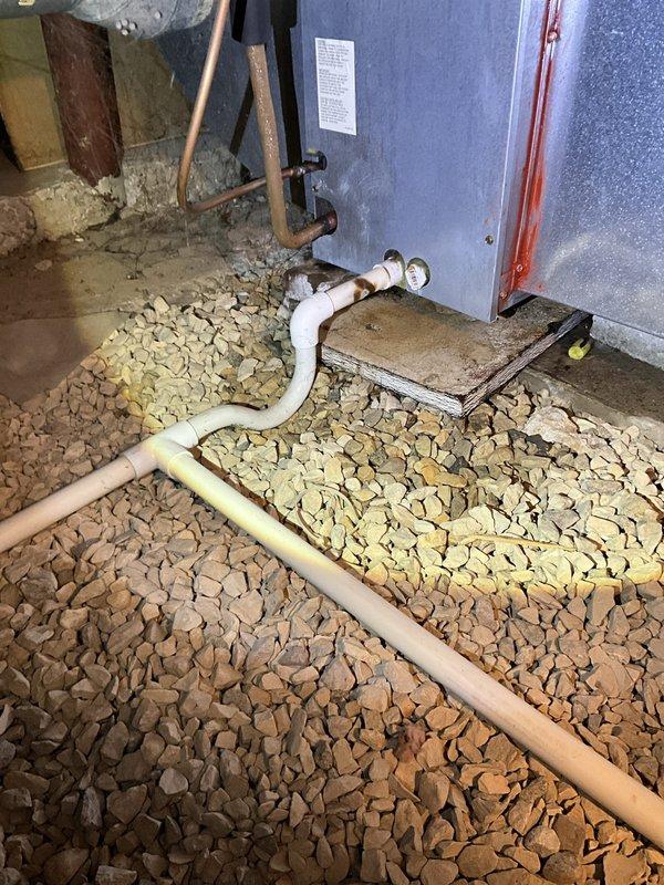 Responded to service call for backed-up condensate drain in crawl space on 20+ year old air conditioning system. Upon arrival, found unit operational and producing cool air as reported. Inspected condensate drainage system and cleared blockage from drain line. Verified proper drainage flow and confirmed system operation. Customer advised of unit age and condition but declined replacement at this time. No further issues found during inspection.