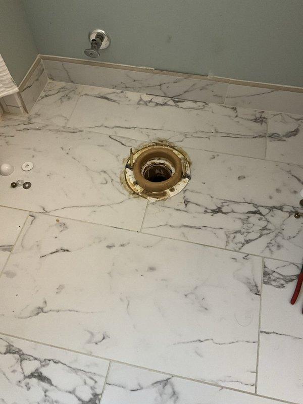 Installed new toilet over existing brass flange on marble-patterned tile floor, ensuring proper leveling and secure mounting to waste pipe connection. Following toilet installation, installed customer-provided bidet toilet seat with all necessary supply lines, fittings, and connections to ensure full operational functionality of the integrated bidet system.