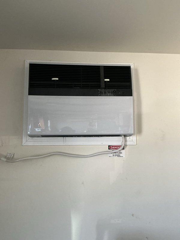 Replaced through-the-wall packaged HVAC unit at commercial facility. Removed existing unit and installed new wall-mounted heat pump system with proper electrical conduit routing and safety labeling. All team members utilized required PPE including steel-toed boots, safety glasses, gloves, hard hats, and high-visibility vests per site safety requirements.