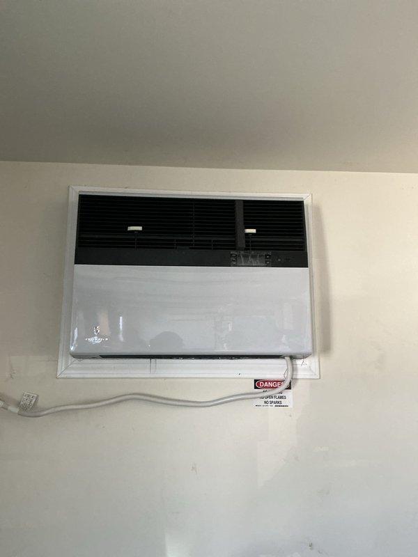 Replaced through-the-wall packaged HVAC unit at commercial facility. Removed existing unit and installed new wall-mounted heat pump system with proper electrical conduit routing and safety labeling. All team members utilized required PPE including steel-toed boots, safety glasses, gloves, hard hats, and high-visibility vests per site safety requirements.