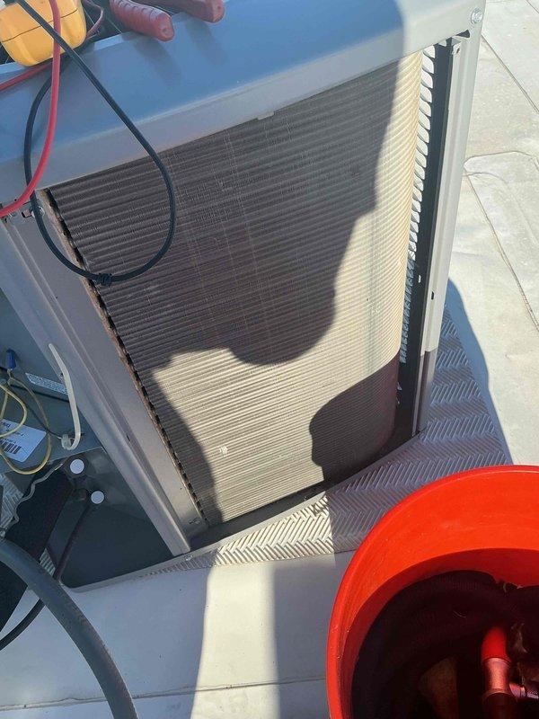 Completed comprehensive BFMA tune-up service on rooftop-mounted air conditioning system over 5 years old. Performed full system inspection including condenser coil examination, verified proper operation of condenser fan assembly, and assessed overall unit condition. All components found operating within normal parameters with equipment showing typical weathering consistent with outdoor rooftop installation.