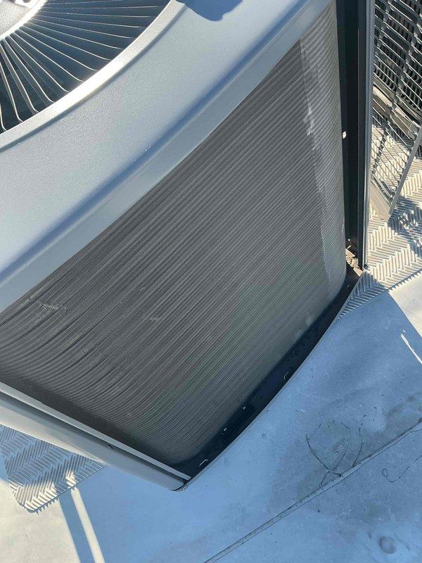 Completed comprehensive BFMA tune-up service on rooftop-mounted air conditioning system over 5 years old. Performed full system inspection including condenser coil examination, verified proper operation of condenser fan assembly, and assessed overall unit condition. All components found operating within normal parameters with equipment showing typical weathering consistent with outdoor rooftop installation.