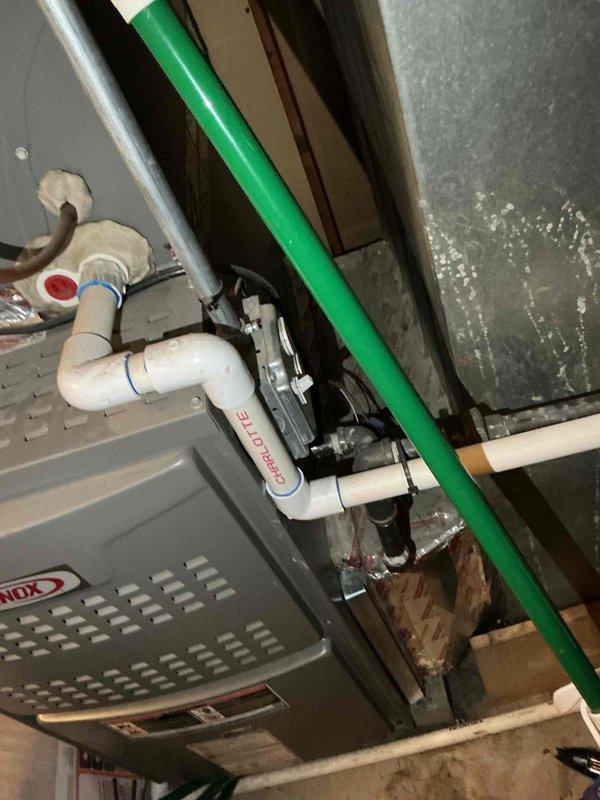 Responded to after hours emergency call for HVAC system failure. Upon arrival, performed diagnostic testing on outdoor condensing unit using digital multimeter. Testing revealed failed run capacitor reading 9.90 microfarads, significantly below manufacturer specifications. Capacitor showed visual signs of deterioration and electrical failure. Replaced defective dual run capacitor with OEM equivalent part, reconnected all electrical terminals, and verified proper wire connections. Tested system operation and confirmed compressor and condenser fan motor startup within normal parameters. Inspected indoor air handler unit and condensate pump assembly in basement for related issues. Verified condensate pump operation, checked PVC drain line routing, and confirmed proper drainage. System restored to full operational status with all components functioning normally.