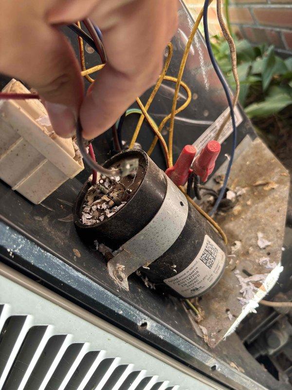 Responded to no cooling call where client reported hot air blowing through vents. Upon inspection, found failed dual run capacitor with visible internal deterioration and debris in top opening. Replaced defective capacitor, verified proper wire connections, and tested system operation. Unit restored to normal cooling function with proper airflow and temperature differential confirmed.