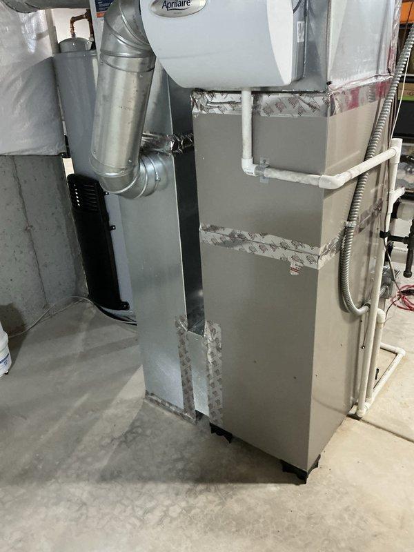 Conducted comprehensive assessment of existing HVAC system for replacement estimate. Evaluated current Goodman furnace installation with Aprilaire humidifier in basement mechanical room. Inspected furnace cabinet condition, noting accessibility panels and insulation integrity. Assessed existing ductwork configuration including gray metal supply ducts with flexible connections and black return air ductwork. Documented PVC drainage lines from humidifier, gas line connections, and overall system layout. Photographed unit specifications and manufacturer labels for equipment sizing and compatibility verification. Evaluated electrical connections and control panel accessibility. Reviewed installation space constraints and clearances for replacement equipment options. Prepared detailed documentation to provide customer with multiple replacement system options including matching A/C and evaporator coil configurations compatible with existing infrastructure and ductwork.