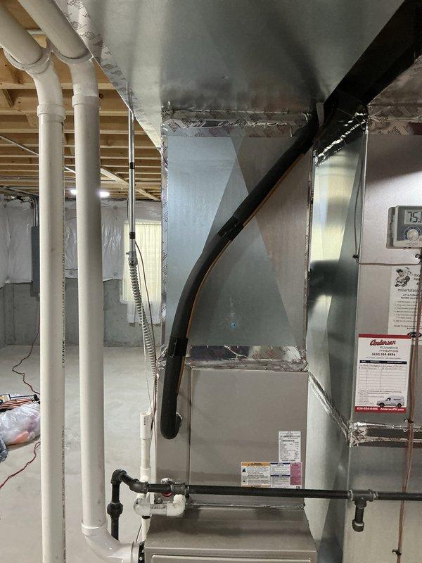 Conducted comprehensive assessment of existing HVAC system for replacement estimate. Evaluated current Goodman furnace installation with Aprilaire humidifier in basement mechanical room. Inspected furnace cabinet condition, noting accessibility panels and insulation integrity. Assessed existing ductwork configuration including gray metal supply ducts with flexible connections and black return air ductwork. Documented PVC drainage lines from humidifier, gas line connections, and overall system layout. Photographed unit specifications and manufacturer labels for equipment sizing and compatibility verification. Evaluated electrical connections and control panel accessibility. Reviewed installation space constraints and clearances for replacement equipment options. Prepared detailed documentation to provide customer with multiple replacement system options including matching A/C and evaporator coil configurations compatible with existing infrastructure and ductwork.