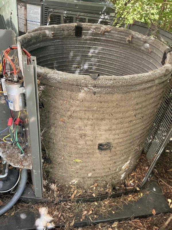 Responded to no cooling complaint on 1-2 year old residential air conditioning system experiencing intermittent cooling issues. Upon inspection, found outdoor condenser coil heavily obstructed with dirt, dust, and debris accumulation, significantly restricting airflow and reducing heat transfer efficiency. Removed outer casing to expose cylindrical condenser coil, which displayed thick layer of organic matter and particulate buildup across entire surface area. Performed thorough coil cleaning to restore proper airflow and system performance, addressing the root cause of intermittent cooling operation.