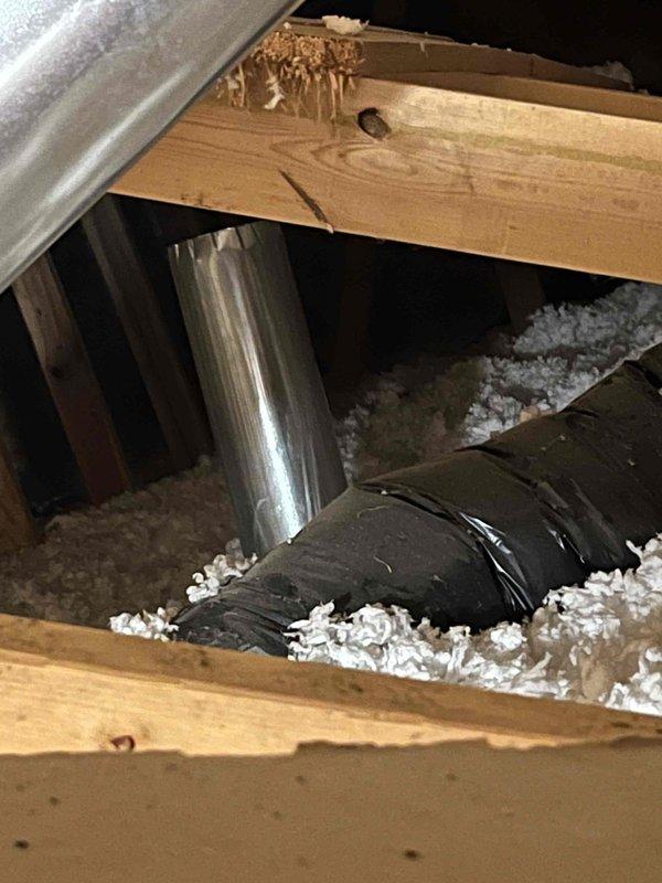 Completed complimentary sump pump inspection and assessment. During service visit, identified additional issues with bathroom exhaust fan requiring attention. Documented bathroom ventilation fan condition, noting 9-inch square ceiling-mounted unit showing significant wear, dust accumulation, and deterioration around frame edges. Inspected attic space above bathroom and photographed ductwork configuration, including metal exhaust duct and flexible ducting running through joists with loose-fill insulation present. Advised client of bathroom fan concerns requiring further discussion regarding necessary repairs or replacement.