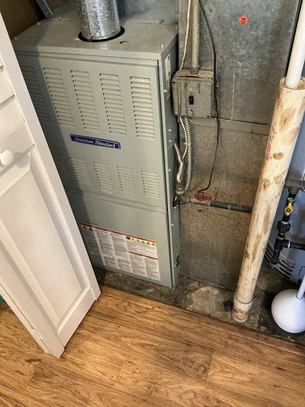Completed comprehensive assessment of existing HVAC system including 18-year-old American Standard furnace and 16-year-old air conditioning unit located in basement utility area. System currently operational but exhibiting underlying performance issues prompting evaluation for full replacement options. Documented existing equipment installation, ductwork configuration, gas line connections, electrical components, and overall system condition through photographic records. Prepared detailed replacement proposal with equipment sizing recommendations tailored to home's specific heating and cooling requirements.