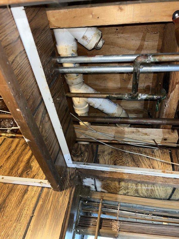 Responded to kitchen sink clog complaint and performed diagnostic inspection of drainage system. Upon investigation, accessed crawl space and inspected plumbing infrastructure, including galvanized steel drain lines and PVC drainage components. Assessed condition of horizontal drain runs and verified proper mounting and support of drain pipes. Cleared blockage and restored proper drainage function to kitchen sink. System tested and confirmed operational upon completion.