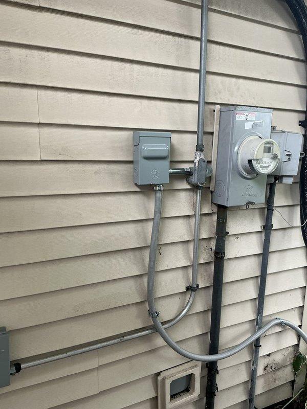 Responded to callback for outdoor condensing unit positioned too close to electrical meter in violation of code requirements. Pumped down refrigerant from MUZ-FX15NLHZ outdoor unit and relocated condenser, rotating 90 degrees perpendicular to house to achieve minimum 3-foot clearance from meter and adequate service access on all sides. Verified electrical installation was complete with proper 20A2P breaker and conduit routing, then recharged system and performed full startup procedures on Mitsubishi mini-split hyper heat system serving sunroom.