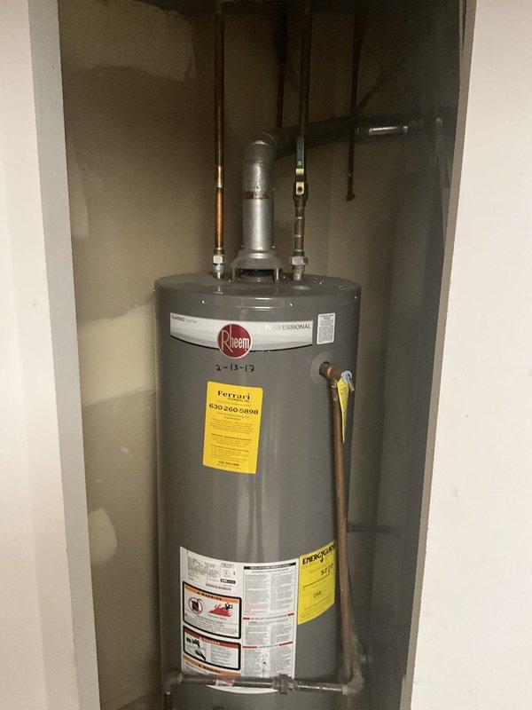 Responded to report of suspected ejector pump or sump pump leak in basement. Upon inspection, examined sump pump system with white PVC discharge piping, red valve assembly, and electrical connections. Verified sump pump basin installation and checked for signs of water intrusion or active leaking around pump components and discharge lines. Also inspected Rheem water heater in adjacent utility closet to rule out alternative water sources. Documented equipment conditions with photos for service records.