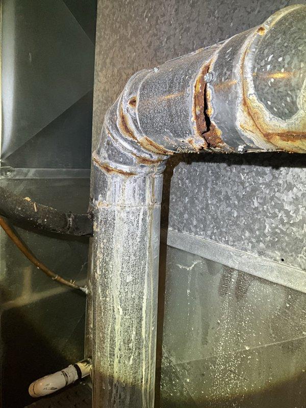 Responded to water leak in front of furnace. Upon arrival, found active water leakage and shut down unit for safety. Inspection revealed severely corroded evaporator coil with significant rust deterioration at top edge and mounting frame, along with corroded drain piping connections showing moisture streaking. Cleaned up standing water and documented extensive corrosion damage requiring coil replacement to prevent future leaks and restore proper system operation.