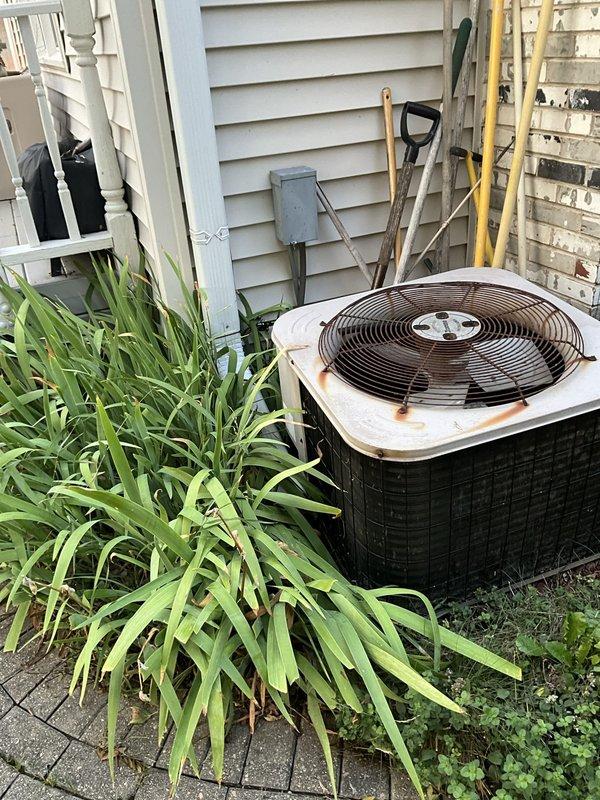 Conducted comprehensive full system HVAC estimate at residential property. Evaluated existing outdoor air conditioning unit showing significant age-related deterioration including extensive rust staining on top panel and weathered components, indicating need for replacement. Inspected basement mechanical area and assessed existing ductwork configuration including metallic supply ducts and flexible return duct system suspended from floor joists. Documented water heater location and existing HVAC infrastructure layout to determine proper equipment sizing and installation requirements. Photographed exterior condensing unit positioned on concrete pad adjacent to home and interior mechanical space to provide accurate proposal for complete system replacement including new furnace and air conditioning equipment.