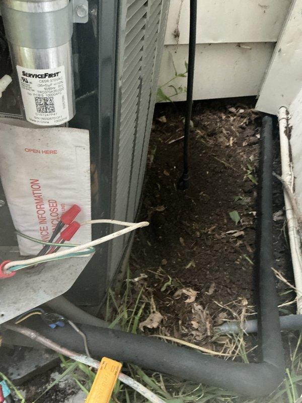 Performed pump down procedure and located refrigerant leak on outdoor line set using UV dye tracing. Identified leak point at section of line set immediately before underground transition, with dye evidence documented in photos. Isolated refrigerant system and removed compromised line set section to prepare for repair, addressing the active leak that was compromising system performance.