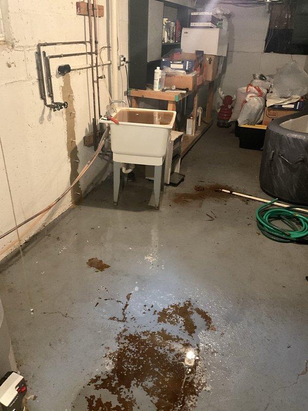 Responded to water softener malfunction causing basement flooding. Upon arrival, found iron breaker system experiencing backflow issues during regeneration cycle, resulting in water overflow from utility sink onto basement floor. Inspected plumbing connections, water softener regeneration valve, and drain line system. Identified blockage in drain line preventing proper discharge during regeneration cycle. Cleared obstruction from drain line, tested regeneration cycle to verify proper water flow and drainage. Confirmed utility sink no longer overflowing and water softener operating correctly. Cleaned affected area and advised on preventive maintenance for water softener system.