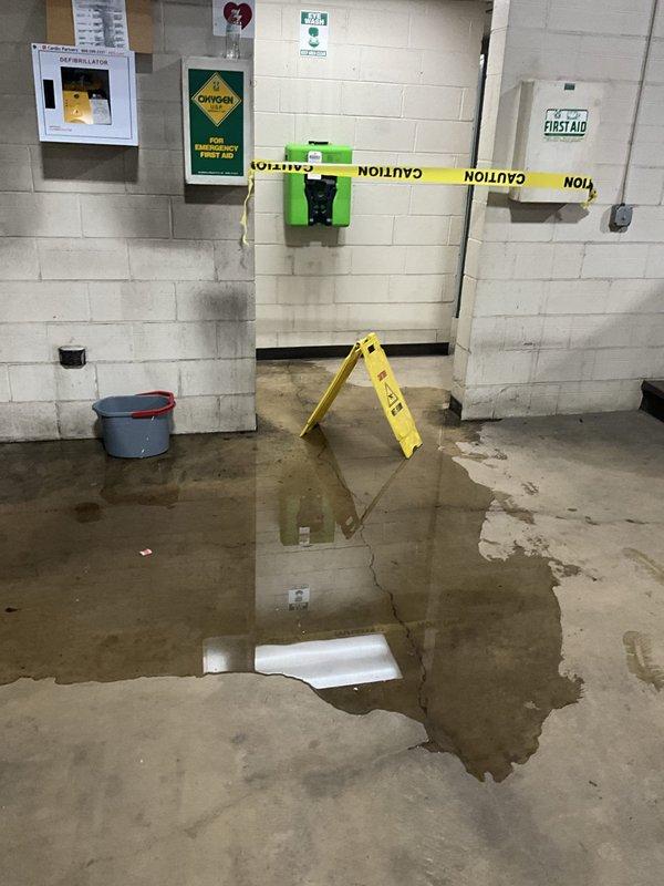 Responded to emergency call for sewer backup and water discharge in commercial restroom facility where toilets had been recently installed. Upon arrival, found extensive water pooling throughout men's restroom with standing water covering floor surfaces near urinals and floor drains. Investigated drainage system to identify cause of backup in newly installed toilet area. Assessed floor drain functionality and cleared obstruction causing water to spew from drain line. Verified proper drainage flow restored to affected fixtures and floor drains. Placed caution signage to alert facility occupants of wet floor conditions during cleanup.
