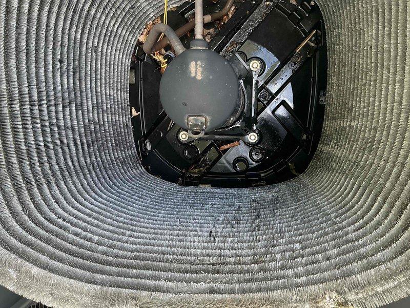 Completed comprehensive BFMA tune-up service on 9-year-old air conditioning system, including inspection of two AC units and compressor sump pump. Performed thorough cleaning of heavily soiled outdoor condenser coils which exhibited significant accumulation of dirt, dust, and organic debris that was restricting airflow and reducing system efficiency. Inspected condenser unit components including compressor, refrigerant lines, electrical connections, and mounting hardware. Noted oxidation on copper refrigerant lines and general wear consistent with equipment age. Verified proper operation of all mechanical components and ensured adequate airflow through cleaned coil assembly to restore optimal cooling performance.