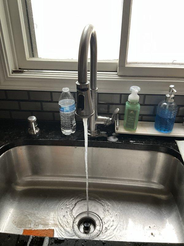 Completed comprehensive new client plumbing inspection of residential property. Evaluated bathroom sink plumbing installation including flexible braided stainless steel supply lines, chrome compression fittings, and white corrugated S-trap drain assembly—all components found in good condition with no visible leaks or corrosion. Inspected kitchen plumbing system including stainless steel sink with chrome arcing faucet and countertop-mounted soap dispenser, verified proper water flow and drainage operation. Addressed client concern regarding sulfur odor in water supply, which typically indicates presence of hydrogen sulfide gas or sulfate-reducing bacteria in water system. Provided instruction on proper operation and maintenance of existing water softener system to client. Scheduled installation of new water filtration system to address water quality concerns. Documented all plumbing conditions with photographs for service records. All inspected plumbing fixtures and connections operatin