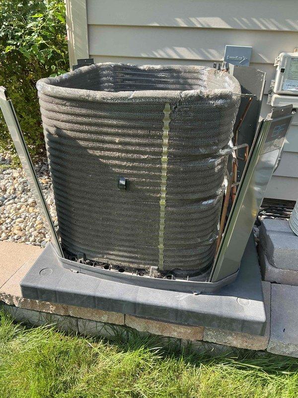 Completed comprehensive BFMA tune-up on 4-year-old residential heat pump system. Performed full inspection of outdoor condenser unit, noting significant accumulation of dirt and debris throughout the coil assembly requiring cleaning. Removed access panels to expose cylindrical coil structure and internal components for thorough maintenance. Inspected compressor unit, electrical connections, and mounting hardware, observing normal wear consistent with system age. Cleaned condenser coils to remove environmental buildup obstructing airflow through fins. Verified proper compressor mounting and base plate integrity. Checked all electrical connections including wiring terminals for secure attachment. Cleared debris from unit base and surrounding area to ensure optimal system performance. System operational and functioning within normal parameters upon completion of preventive maintenance service.