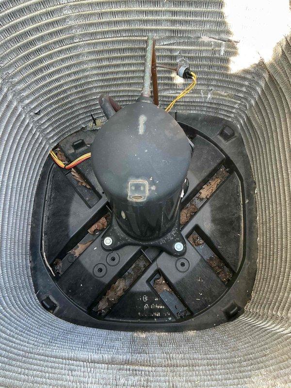 Completed comprehensive BFMA tune-up on 4-year-old residential heat pump system. Performed full inspection of outdoor condenser unit, noting significant accumulation of dirt and debris throughout the coil assembly requiring cleaning. Removed access panels to expose cylindrical coil structure and internal components for thorough maintenance. Inspected compressor unit, electrical connections, and mounting hardware, observing normal wear consistent with system age. Cleaned condenser coils to remove environmental buildup obstructing airflow through fins. Verified proper compressor mounting and base plate integrity. Checked all electrical connections including wiring terminals for secure attachment. Cleared debris from unit base and surrounding area to ensure optimal system performance. System operational and functioning within normal parameters upon completion of preventive maintenance service.