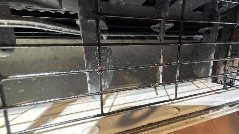 Performed system restoration on wall-mounted air conditioning unit. Inspected internal components including evaporator coil assembly, drain pan, and air filter, noting evidence of water staining and accumulated debris in base pan. Addressed system issues to restore proper operation and functionality per customer's specific service request.