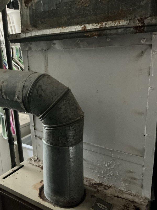 Conducted on-site evaluation of existing outdoor condensing unit and indoor coil system for replacement estimate. Unit is 25+ years old and beyond economical repair. Inspected outdoor condenser positioned on concrete pad with gravel surround, noting weathered cabinet condition, aged fan assembly with hexagonal guard, and deteriorated metal casing consistent with extended service life. Evaluated indoor coil location in basement utility area with existing ductwork connections. Documented current system configuration including refrigerant line routing, electrical conduit placement, and mounting specifications. Assessed installation area conditions and confirmed adequate clearances for replacement equipment. Provided comprehensive replacement options for complete air conditioning system including new condensing unit and evaporator coil to restore cooling capacity and improve energy efficiency.