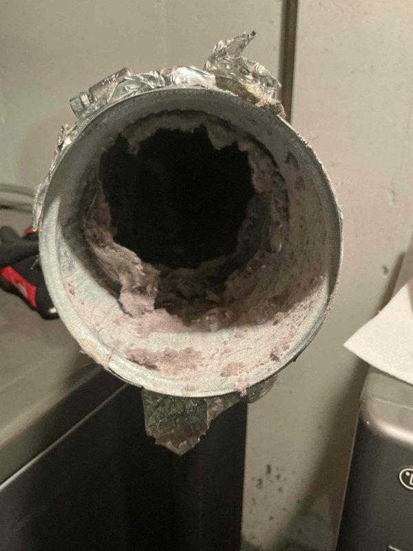 Completed comprehensive air conditioning tune-up on residential split system. Outdoor condenser unit exhibited heavy accumulation of dust, debris, and contamination on coil fins, significantly restricting airflow and reducing heat transfer efficiency. Thoroughly cleaned condenser coils to restore proper airflow and system performance. Inspected compressor and refrigerant lines, confirming proper operation and connections. Additionally performed dryer vent cleaning service, removing substantial buildup of lint and debris from ductwork interior. System tested and verified operational upon completion.