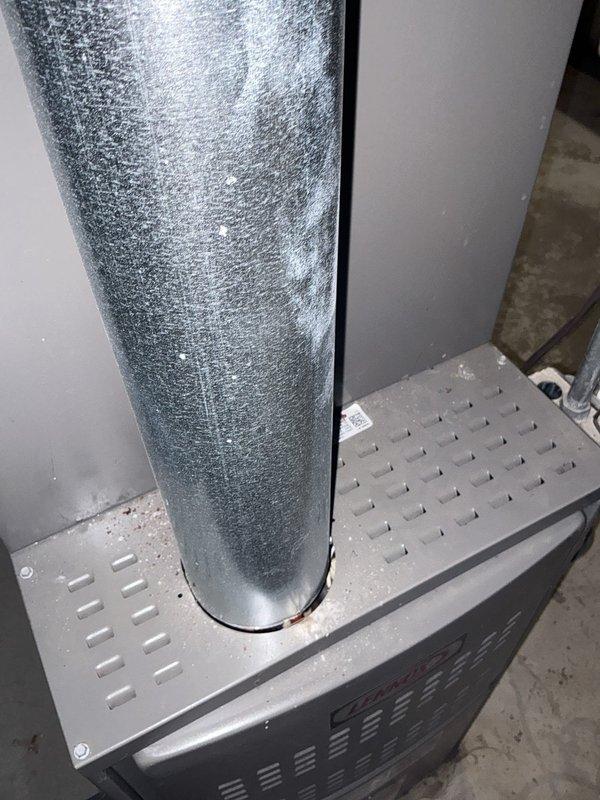 Performed comprehensive evaluation of residential HVAC system with confirmed evaporator coil refrigerant leak that had previously failed repair attempts. Assessed existing single-stage air conditioning unit and two-stage variable-speed heating system installed in basement mechanical room. Documented current system configuration including gray metal furnace cabinet, vertical ductwork with reflective insulation, PVC condensate drain lines, and electrical connections. Provided detailed estimate for complete A/C and coil replacement to resolve ongoing refrigerant leak issue and restore system reliability.
