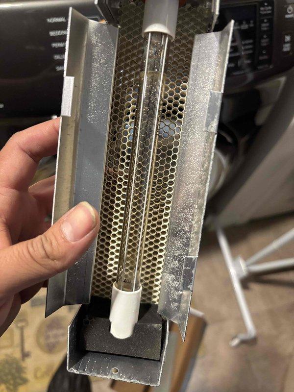 Replaced UV bulb assembly in HVAC system as part of scheduled maintenance. Removed existing UV light component showing dust accumulation on heat exchanger fins and honeycomb mesh filter, installed new bulb unit, and verified proper operation of system upon completion.