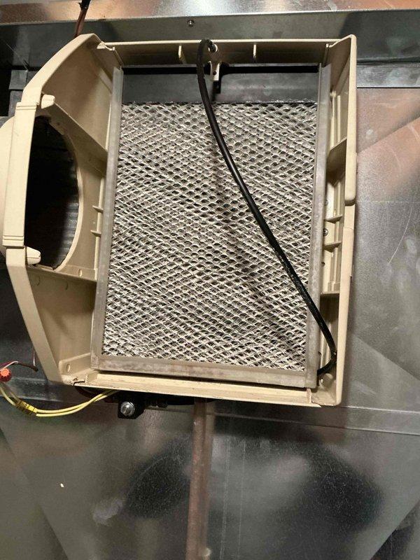 Completed comprehensive HVAC tune-up maintenance on residential heating and cooling system. Performed standard preventive maintenance procedures including system inspection, filter assessment, and component evaluation. Discovered heavily soiled humidifier filter pad with significant dust and debris accumulation requiring replacement. Removed and documented condition of clogged mesh filter element from humidifier assembly, which was restricting proper airflow and humidity distribution. Cleaned humidifier housing unit and surrounding ductwork connections. Both heating and cooling systems were found operating within normal parameters at time of service. Provided customer with service updates via text message as requested throughout the appointment.